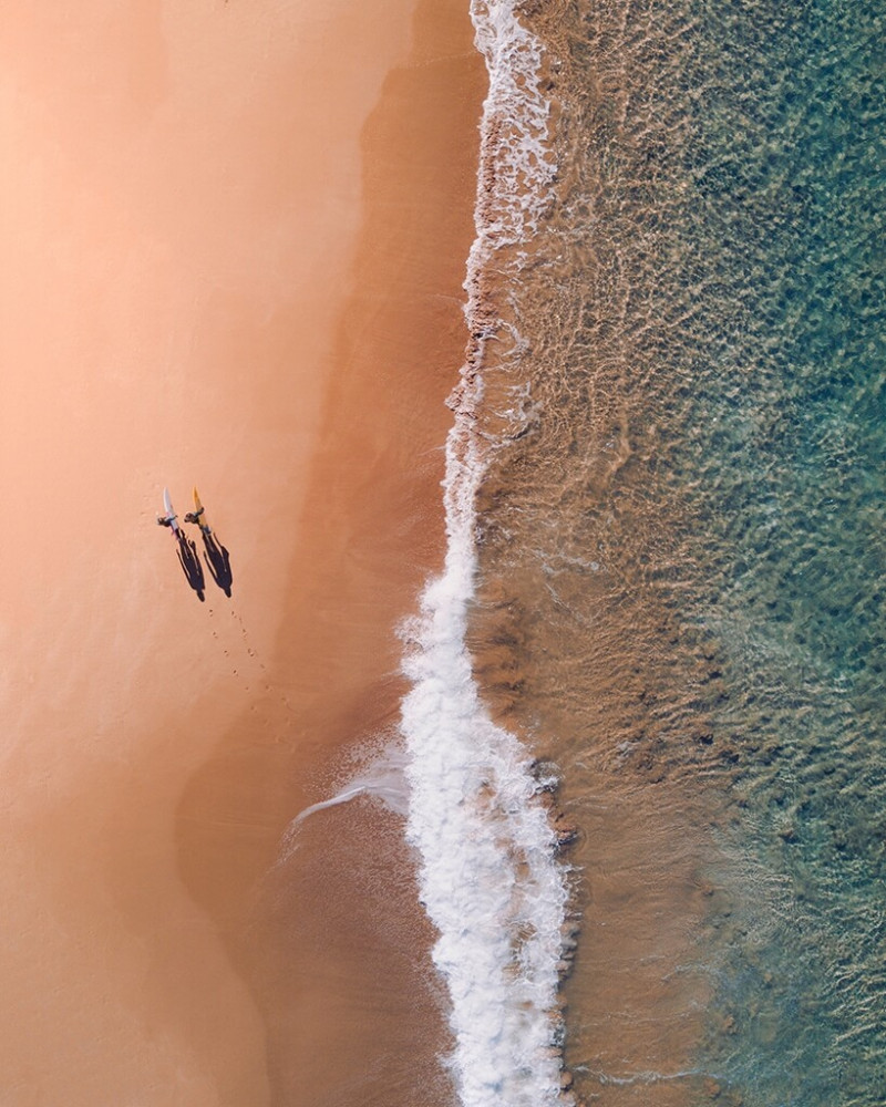 Two surfers walking on the beach